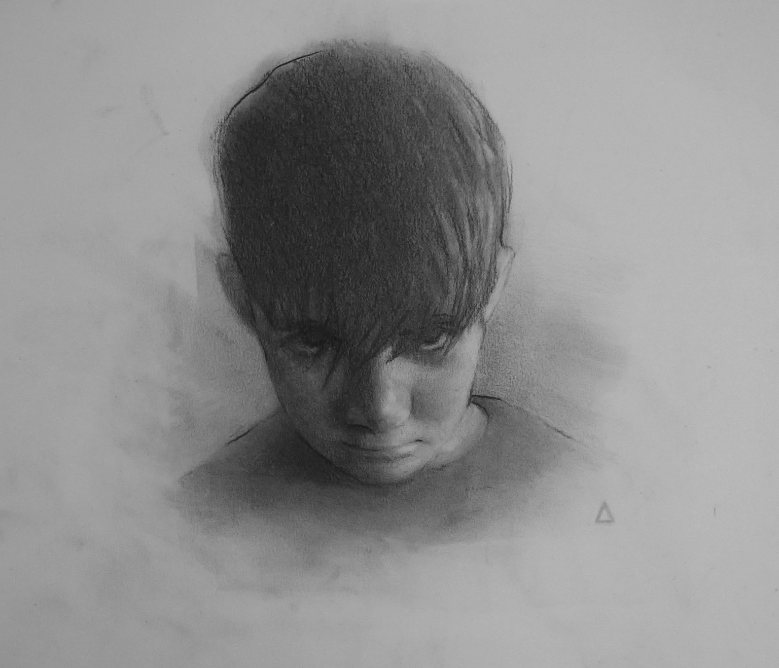 Graphite portrait of a person with lowered head and hair covering the face